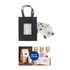 A small black vertical paper bag with knitted handles and a decorative tag, accompanied by various stickers.