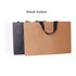 A medium paper bag with flat handles in brown, black, and white colours, featuring a logo.