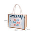 A canvas and jute tote bag in blue and beige, featuring a vibrant design with the word "SUMMER" and a logo.