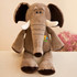 A plush elephant toy in brown, featuring white tusks and black details, with a logo on its chest.