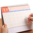 A desk calendar featuring a spiral binding with a colourful top section and a blank monthly layout for January 2025.