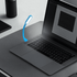 A blue flexible light is positioned next to a laptop on a flat surface, highlighting the keyboard area.
