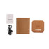 A square cork wireless charger in tan, accompanied by a USB cable and a small instruction booklet.