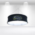 A round hanging banner in black with a logo, illuminated from within, featuring a starry design.