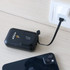 A black 10000mAh eco portable fast charging power bank connected to a charger, with a smartphone nearby.