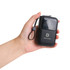 A black 10,000mAh eco portable fast charging power bank held in a hand, featuring a logo and a strap.