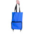 A blue collapsible shopping trolley bag with black accents and straps being held by a hand.