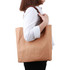 A brown washable kraft paper bag with a PU handle, featuring a simple design and a side view of a person holding it.