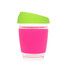 A reusable glass coffee cup in pink with a green lid and a silicone grip. It features a logo on the side.
