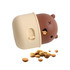 A brown and cream dog treat dispenser toy, shaped like a bear, with kibble scattered around it.