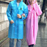 A blue and pink reusable PEVA raincoat with hoods worn by two individuals standing outdoors. Each coat features a logo.