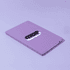 A purple A5 notebook with a smooth finish and a logo on the cover, lying flat on a light background.
