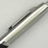 A silver pen with a black grip and a metal clip, featuring branding on the barrel.