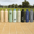 A drink bottle collection in pastel shades, including pink, green, and black, featuring various brands and logos.