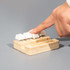 A bamboo stand holder with three white key-shaped buttons, designed for stress relief, featuring a logo.