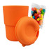 A reusable coffee cup in vibrant orange silicone, accompanied by a bag of colourful jelly beans.
