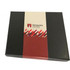 A black gift box featuring a red and white label with a logo, containing assorted chocolates or truffles.