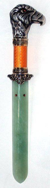 The handle of the book knife is the head of a bird in silver mounted on a column of  pale orange guilloche enamel with decorative gold gilt foliage at each end. There are six garnet cabochons; two for the bird's eyes and four set on the blade. The blade is a pale green nephrite jade.