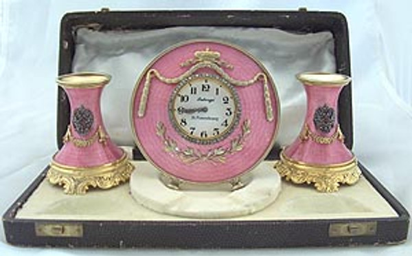 Both the clock and candlesticks are marked with the name "Faberge" in Cyrilllic, the initials "H.W." for Henrik Wigstrom, the silver quality mark "84," and a right facing kokoshnik with the alpha symbol representing the city of St. Petersburg.