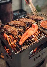 Food cooking outdoors on the Höfats Beer Box portable barbecue