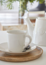 Costa Nova Teapot and Cup and saucer serving tea on a table. Costa Nova Teapot and Cup and saucer serving tea on a table.