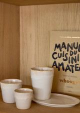 a selection of white costa nova grespresso cups on a wooden shelf
