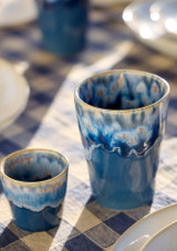 two Costa Nova Grespresso cups in Denim blue on a table in the sun