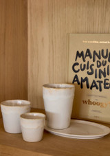 3 white Grespresso cups on a table.