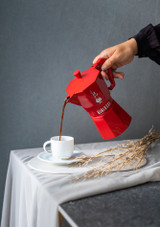 pouring a cup of coffee from the Bialetti Moka Exclusive Express Red – 6 Cup