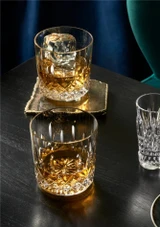 Waterford Giftology Lismore Tumblers 230ml - Set of 2 the glasses on a black table filled with whiskey