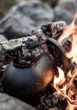 Petromax Cast-Iron Potato Cooker PTO30 – oval-shaped cast iron roaster with hinge and tilt-bolt closure, shown on a white background closed on an open fire.
