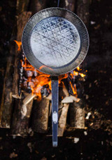 Petromax Wrought Iron Pan SP28 – 28 cm diameter pan with welded iron handle, shown in use on open fire.