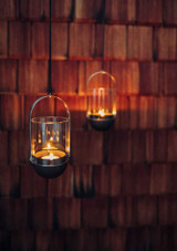 two lit hanging Höfats Gravity Candle Lanterns in Black