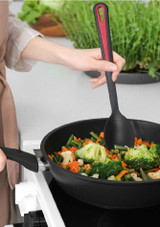 Westmark Gallant Oval Vegetable Spoon lifestyle shot of a woman cooking using the spoon