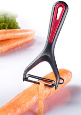 Westmark Gallant Vegetable & Asparagus Peeler with Ceramic Blade on a white background being used to peel a carrot