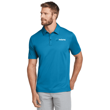 Model is wearing TravisMathew Oceanside Solid Polo in Blue color