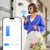 Woman using Connect SmartHome app to control curtains remotely via smartphone