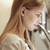 woman using Baseus Bowie WM01 black wireless earbuds side view