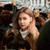Woman on public transport wearing Baseus Bowie WM01 white wireless earbuds for commuting and calls
