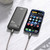 Laser 10000mAh power bank charging a smartphone through USB-C on a light timber desk