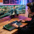 Person using the black RGB gaming keyboard at a desktop gaming setup