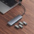 Baseus UltraJoy Lite hub connected to a laptop on a wooden desk beside four flash drives