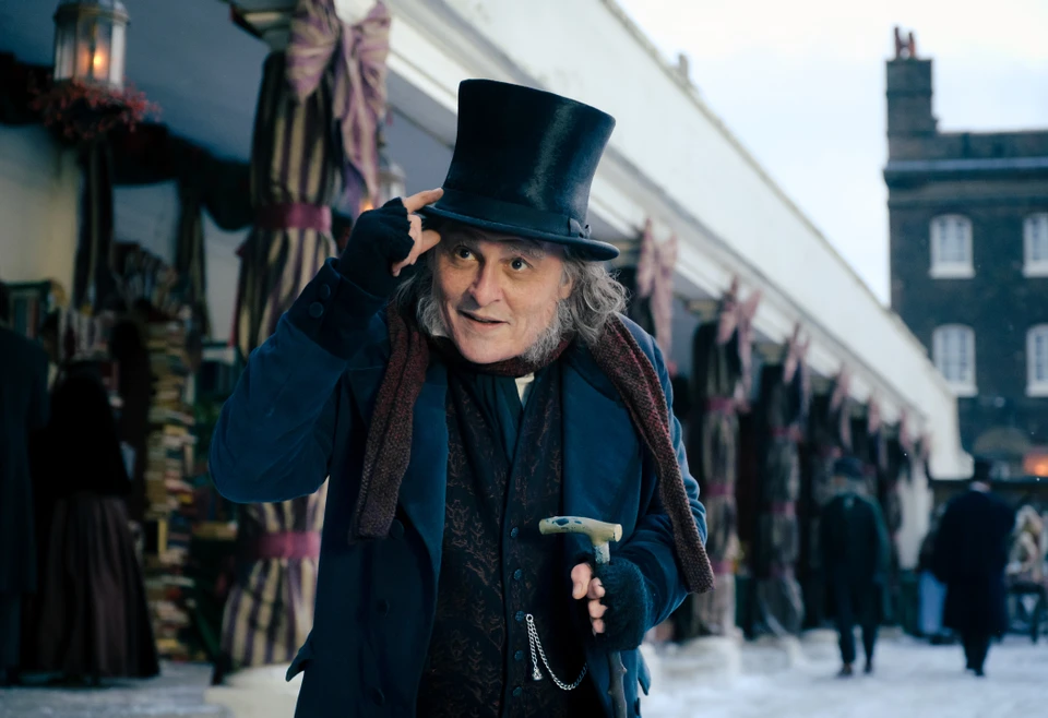 Ebenezer tipping his top hat on a snowy street