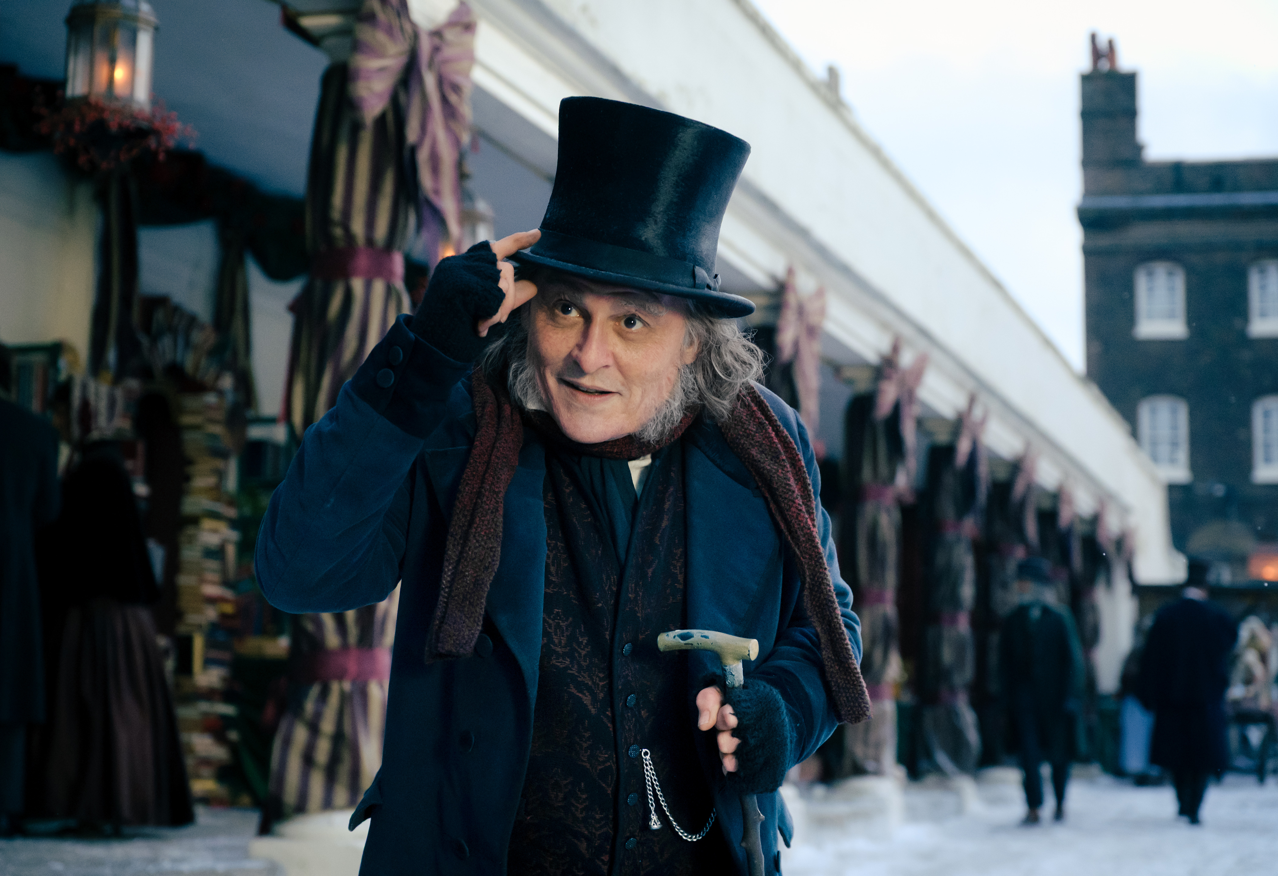 Ebenezer tipping his top hat on a snowy street