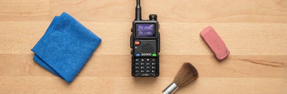 Walkie Talkie maintenance tools including a microfiber cloth and brush next to a Baofeng radio