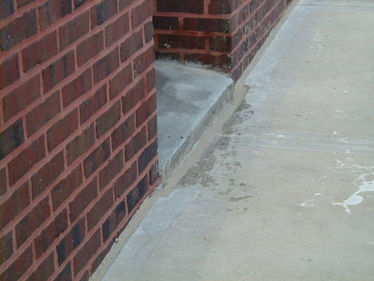 Clean and seal expansion joint between brick wall and sidewalk