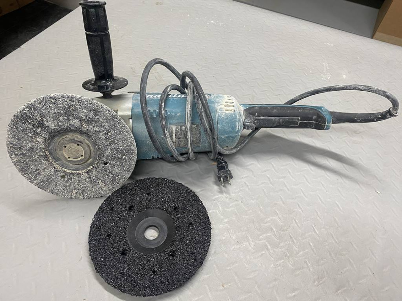 Black grinding wheel mounted on a 7 inch hand grinder