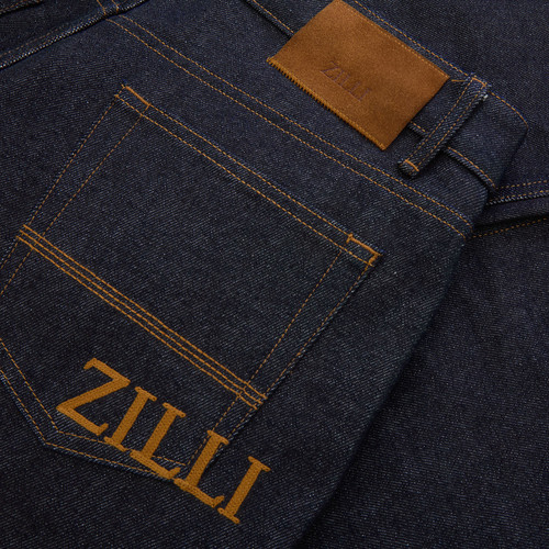 Raw blue jeans, wide fit, camel stitching