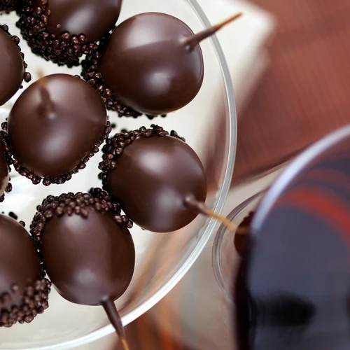 A top-down view of a tray holding several "La Guinette" dark chocolate-coated cherries with Armagnac, from Mademoiselle de Margaux.