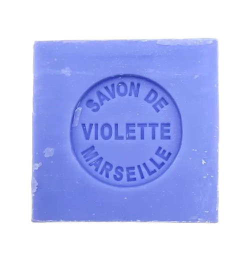 A 100 gram violet colored cube of Senteurs de France's violet-scented Marseille cube. The cube is embossed with the words, "Savon de violette Marseille."